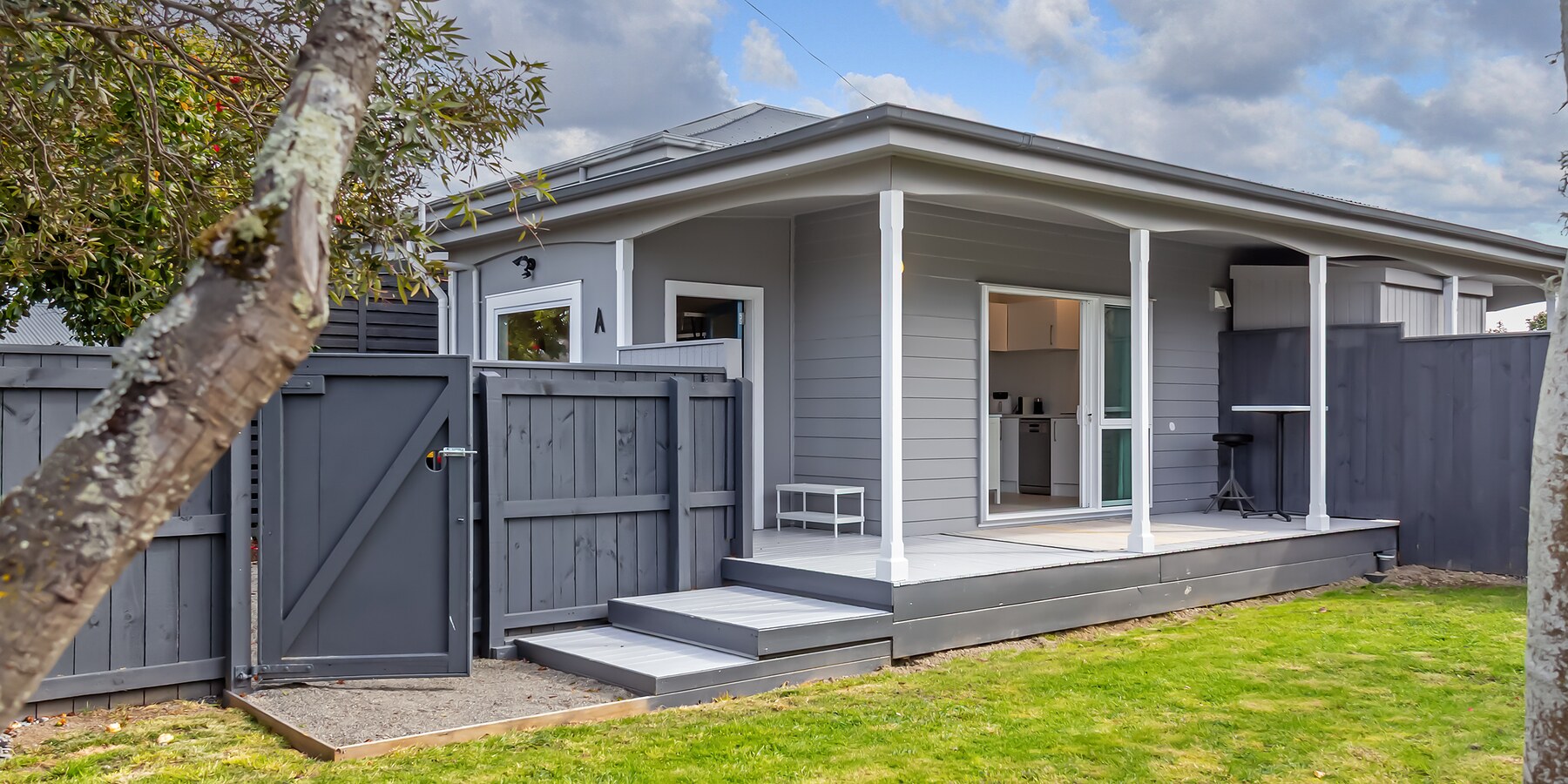 An executive apartment from the garden — covered deck, private gate, lawn