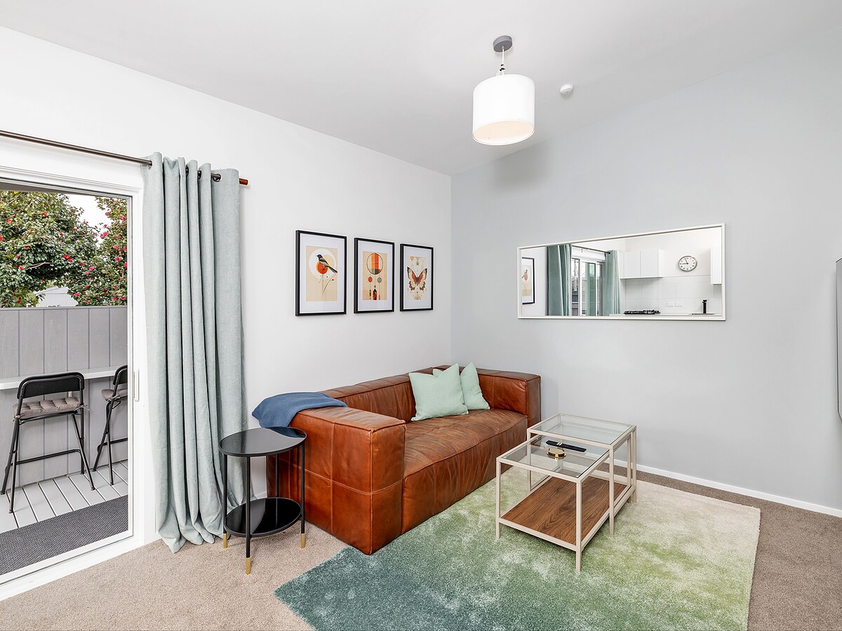 An executive apartment living room, doors open to the deck