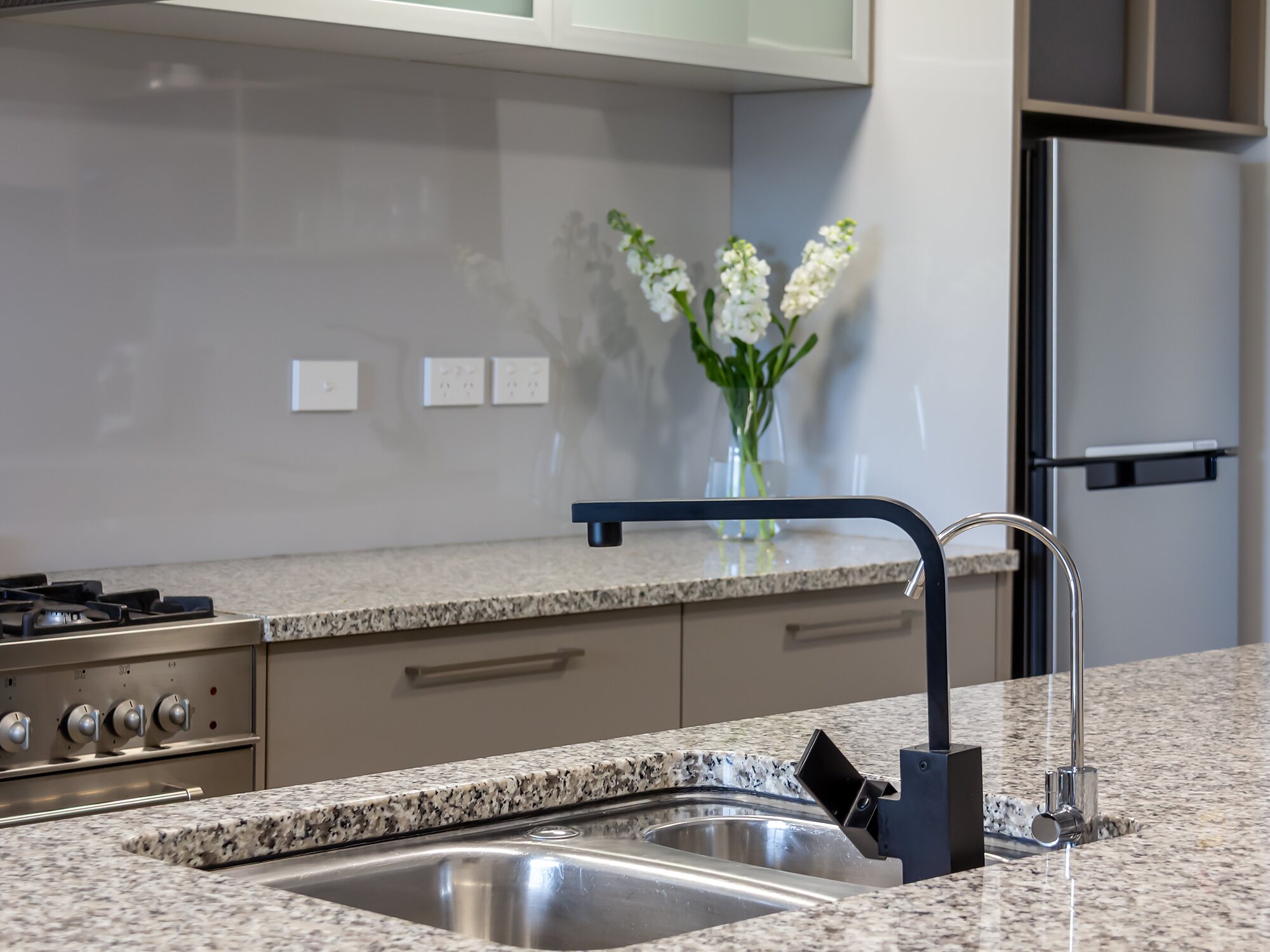 The shared chef's kitchen — granite island, gas range and breakfast bar