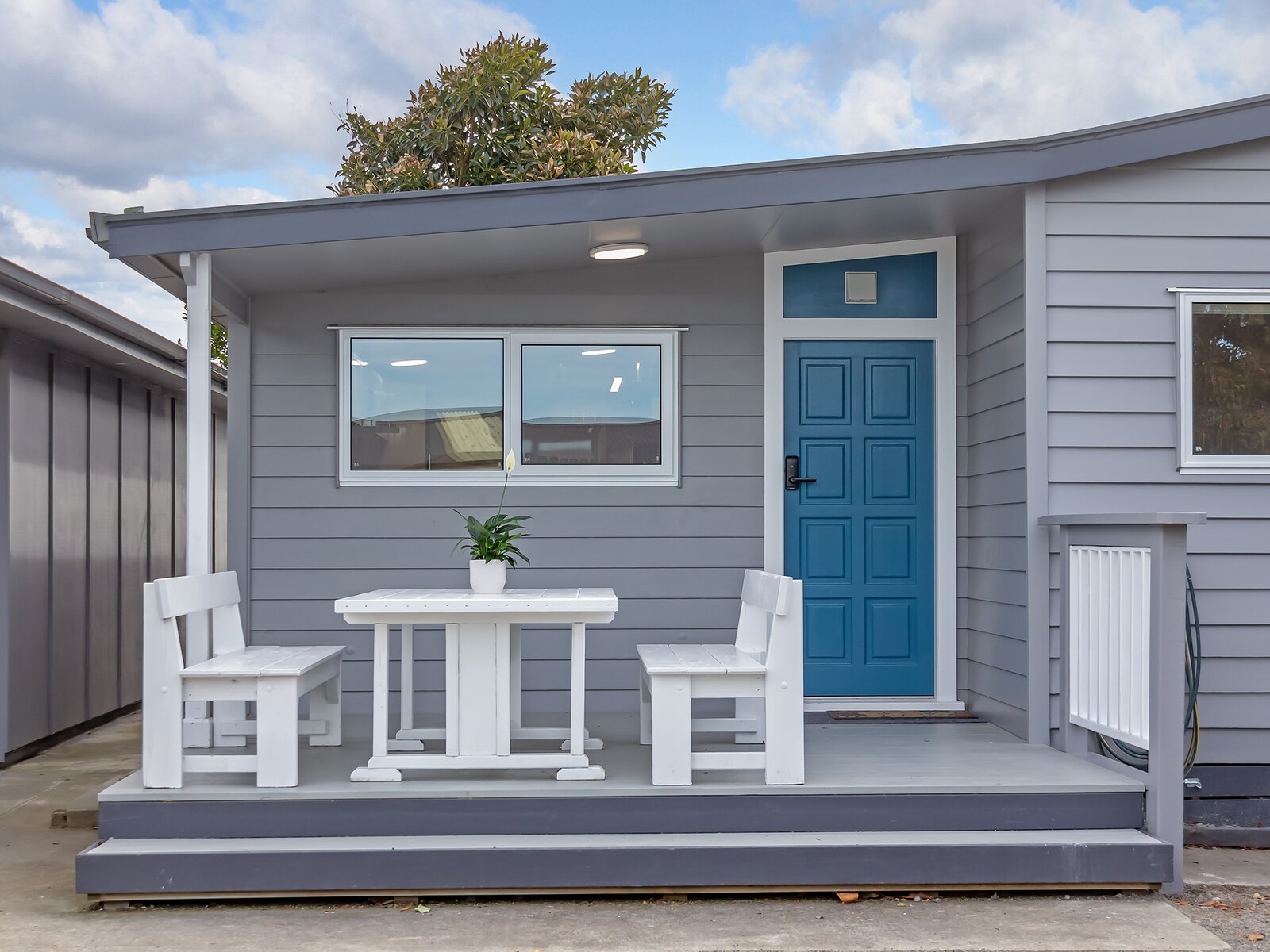 The wing's shared table and chairs on the covered deck outside the kitchen door